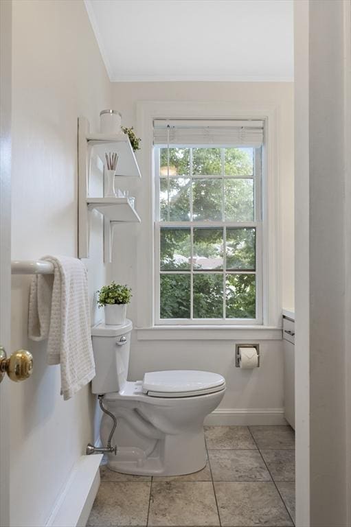 bathroom with crown molding, toilet, baseboards, and tile patterned floors