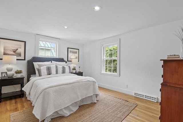 bedroom featuring recessed lighting, wood finished floors, visible vents, and multiple windows