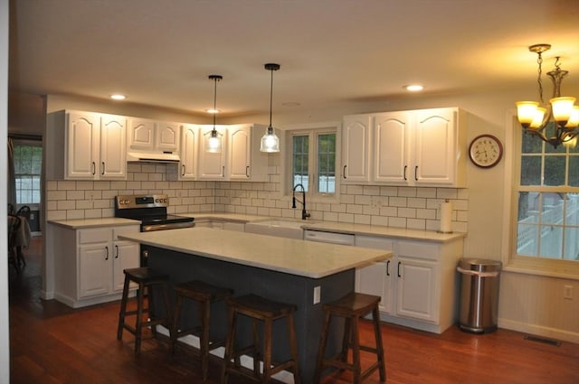 34 Liberty Ln, Ashburnham, MA 01430 - kitchen with a sink, stainless steel electric stove, a kitchen bar, under cabinet range hood, and dark wood-style floors