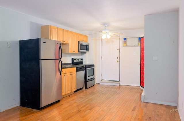 kitchen with light brown cabinets, stainless steel appliances, ceiling fan, and light wood-type flooring