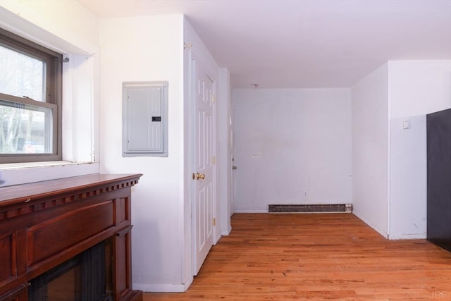 hallway with electric panel and light hardwood / wood-style floors