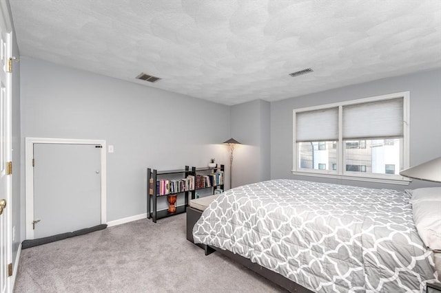 carpeted bedroom with a textured ceiling, visible vents, and baseboards