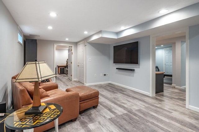 living room featuring recessed lighting, baseboards, and wood finished floors