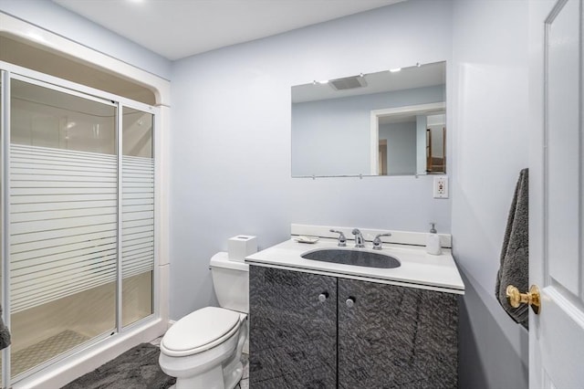 full bathroom with vanity, a shower stall, and toilet