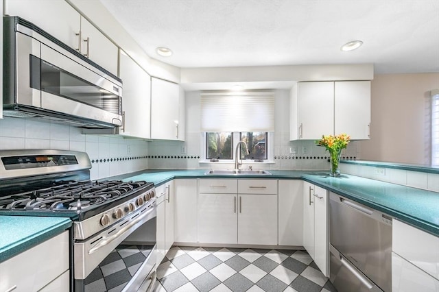 kitchen featuring light floors, plenty of natural light, appliances with stainless steel finishes, and a sink