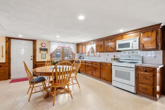 kitchen featuring tasteful backsplash and white appliances