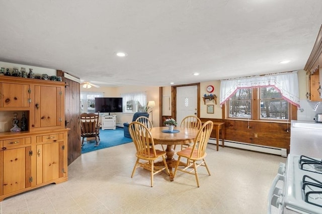 dining space with a baseboard heating unit and wood walls