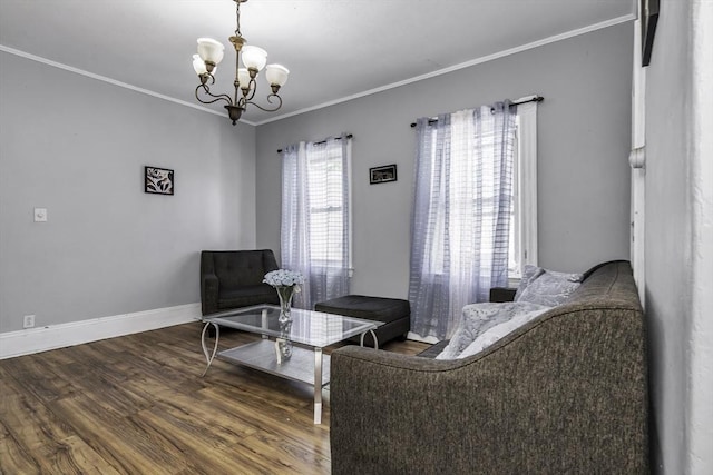 living area with wood finished floors, a chandelier, ornamental molding, and baseboards