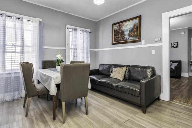 dining room featuring ornamental molding and light wood-style floors