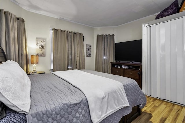 bedroom featuring wood finished floors and ornamental molding