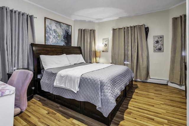 bedroom featuring ornamental molding and wood finished floors