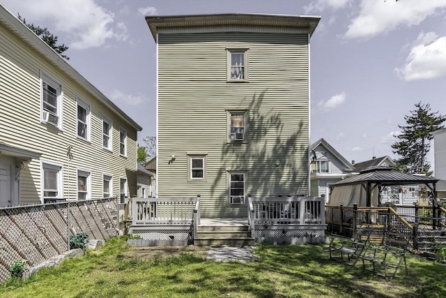 rear view of house featuring a gazebo and a wooden deck