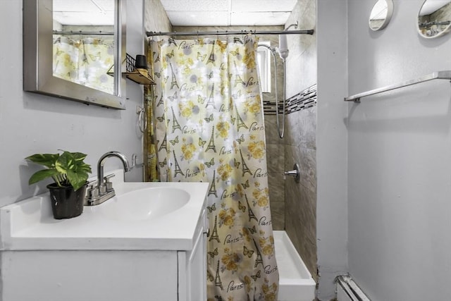 full bathroom with a stall shower, a drop ceiling, and vanity