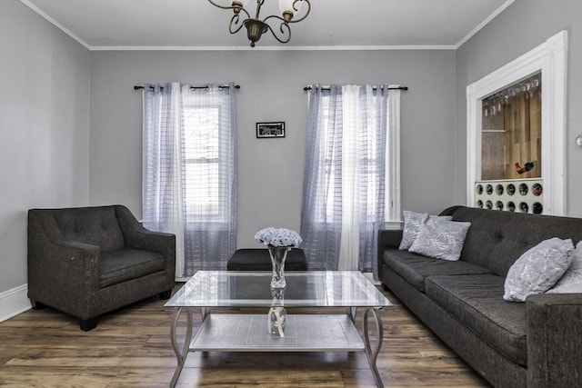 living area with wood finished floors, crown molding, a chandelier, and baseboards