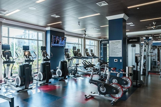 workout area with a ceiling fan, crown molding, a healthy amount of sunlight, and visible vents