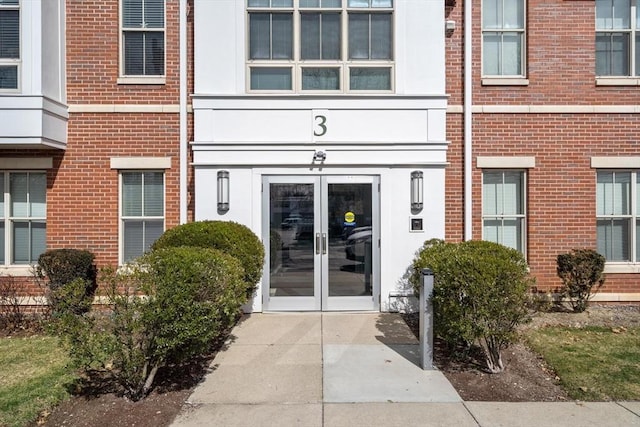 entrance to property featuring french doors and brick siding