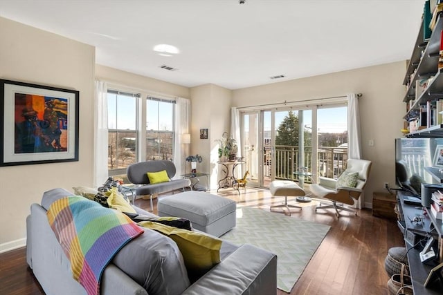 living room with visible vents, baseboards, and hardwood / wood-style flooring