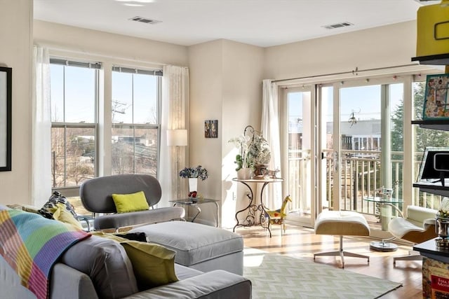 living room with plenty of natural light, wood finished floors, and visible vents