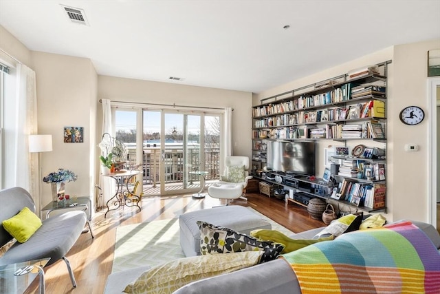 living area featuring wood finished floors and visible vents