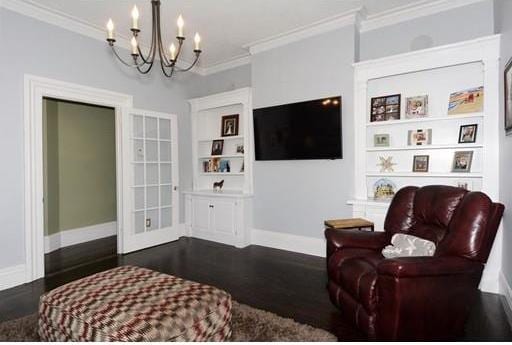 living room featuring dark hardwood / wood-style floors, an inviting chandelier, and ornamental molding