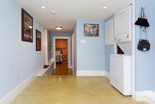 hallway featuring light wood-type flooring and stacked washer and clothes dryer