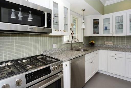 kitchen featuring backsplash, white cabinetry, appliances with stainless steel finishes, and sink