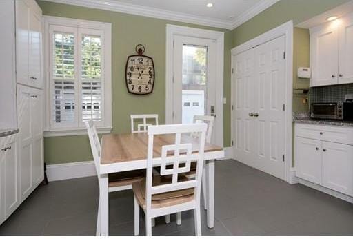 dining room with ornamental molding and a wealth of natural light