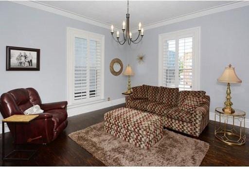 living room featuring crown molding, a notable chandelier, and dark hardwood / wood-style floors