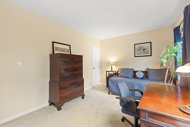 bedroom with light carpet, baseboards, and a desk
