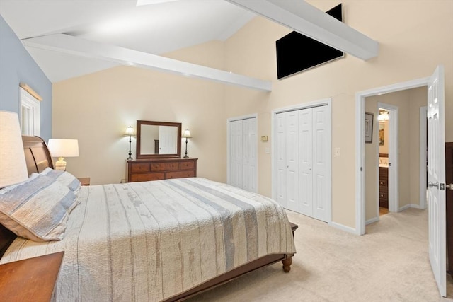 bedroom featuring light carpet, multiple closets, and baseboards