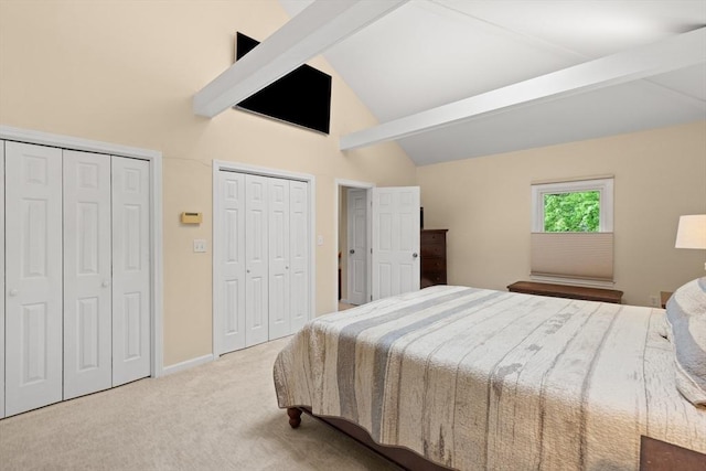 carpeted bedroom with two closets, beam ceiling, high vaulted ceiling, and baseboards