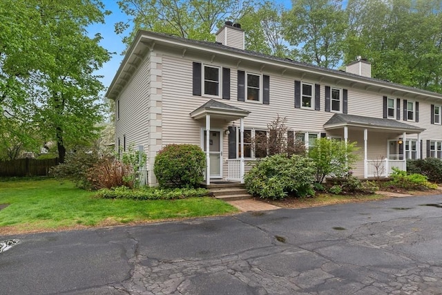 view of front of home with a chimney and a front yard