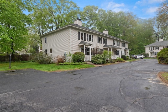 view of front of home with a chimney and fence