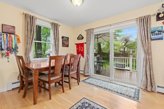dining area featuring wood-type flooring and a baseboard heating unit