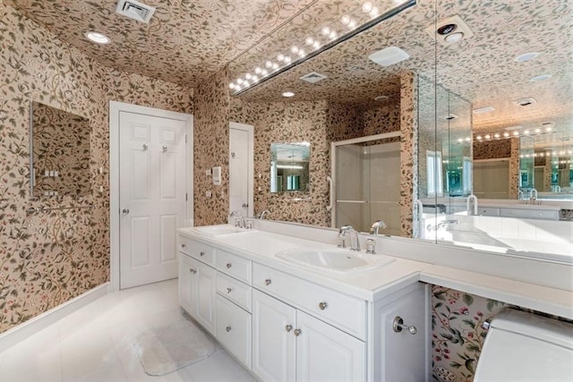 bathroom featuring tile patterned flooring, vanity, and a shower with shower door