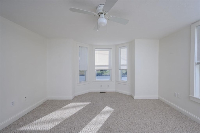 unfurnished room with light colored carpet and ceiling fan