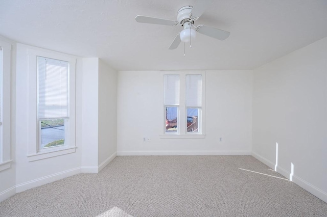 spare room with ceiling fan and light colored carpet