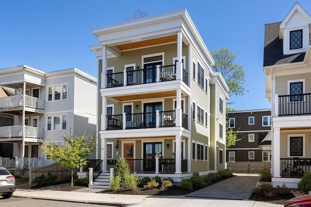 view of front of home featuring french doors, fence, and a balcony