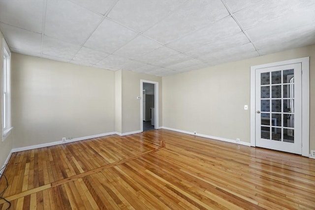 unfurnished room featuring baseboards and light wood finished floors