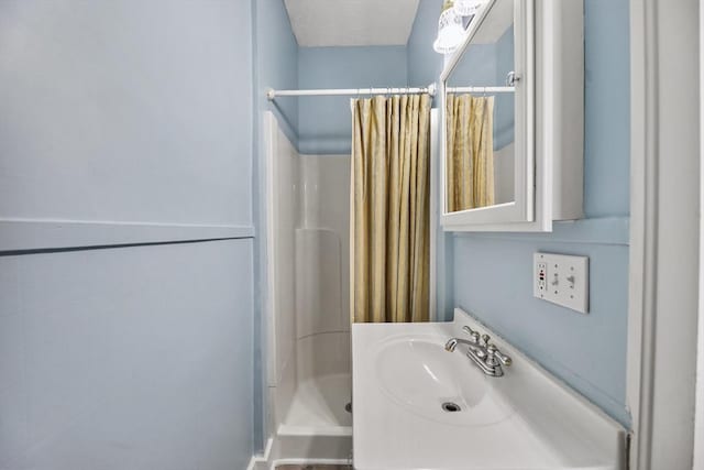 bathroom with a sink and a shower stall