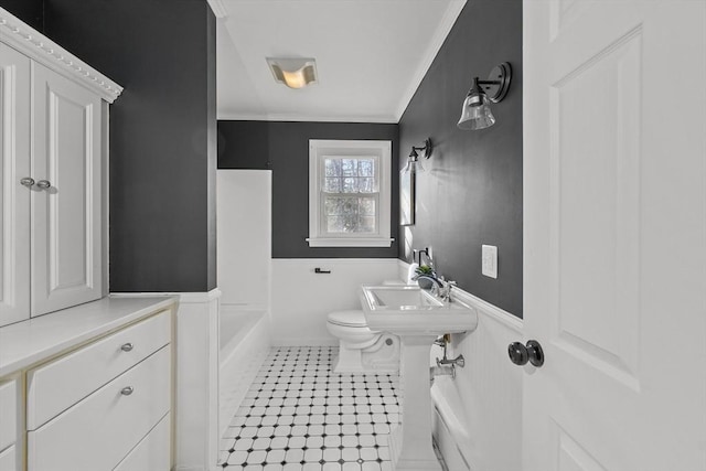 bathroom with crown molding, sink, a bathtub, and toilet