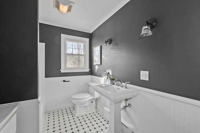 bathroom featuring crown molding and toilet