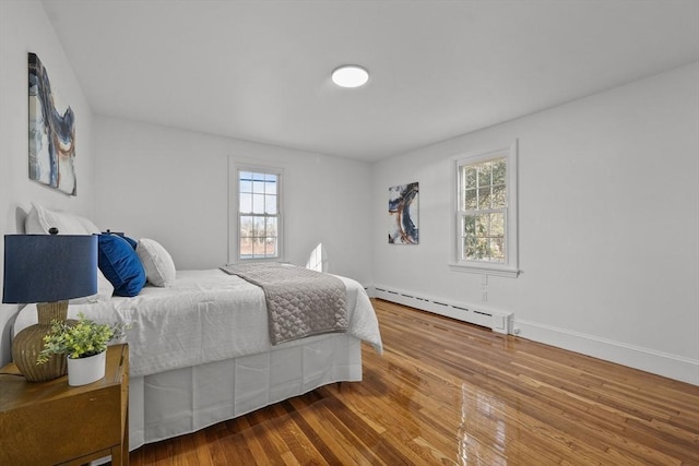 bedroom featuring hardwood / wood-style flooring and baseboard heating