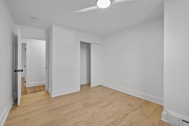 unfurnished bedroom featuring light hardwood / wood-style floors and a closet