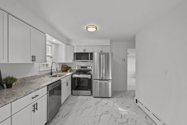 kitchen featuring sink, baseboard heating, appliances with stainless steel finishes, light stone countertops, and white cabinets