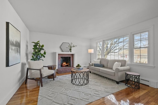 living room with hardwood / wood-style floors, a fireplace, and baseboard heating