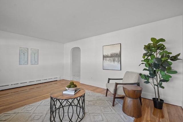 sitting room featuring a baseboard heating unit and light hardwood / wood-style flooring