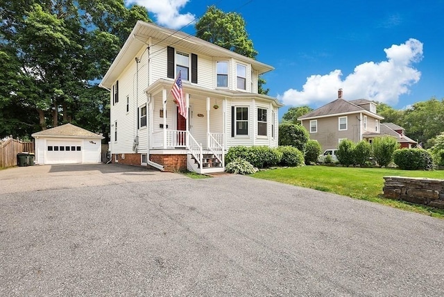311 Main St, Franklin, MA 02038 - view of front of house with an outdoor structure, a detached garage, a front lawn, asphalt driveway, and covered porch