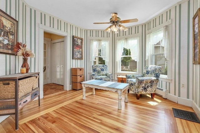 311 Main St, Franklin, MA 02038 - sitting room featuring wallpapered walls, light wood finished floors, ceiling fan, plenty of natural light, and a baseboard heating unit
