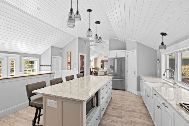 16 W Wind Acres, Norwell, MA 02061 - kitchen with appliances with stainless steel finishes, lofted ceiling, a sink, light wood-type flooring, and a kitchen breakfast bar